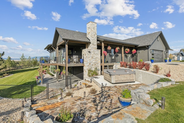 back of property featuring a yard, a hot tub, and a garage