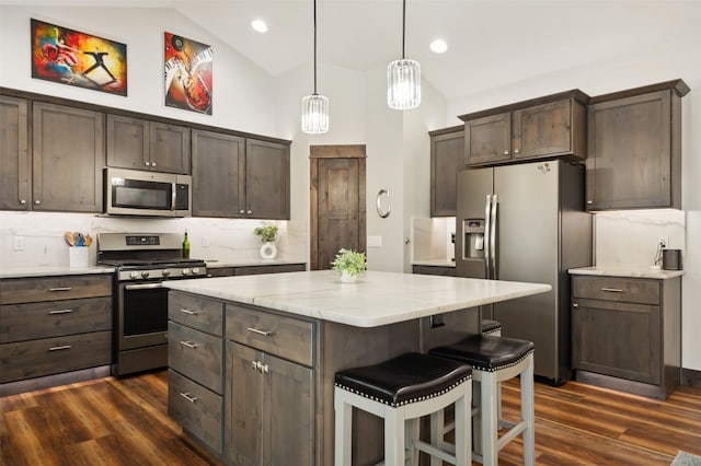 kitchen featuring a center island, dark hardwood / wood-style flooring, dark brown cabinetry, and stainless steel appliances