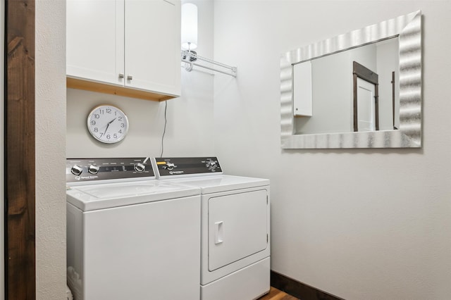 laundry room featuring washer and clothes dryer and cabinets