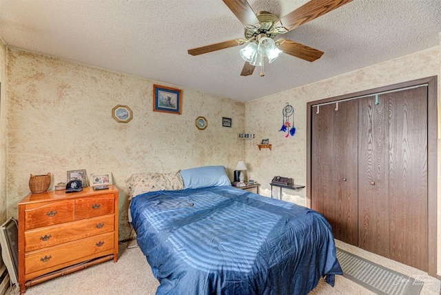 carpeted bedroom featuring ceiling fan, a textured ceiling, and a closet