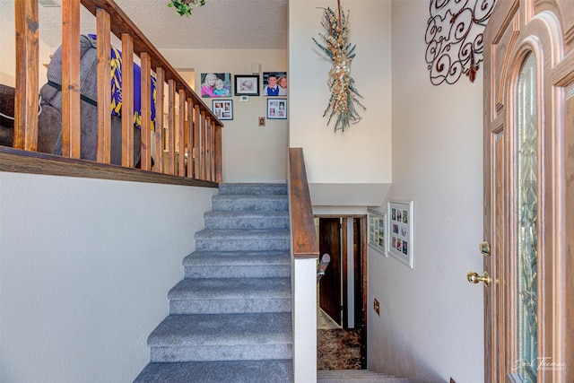 stairs with a textured ceiling