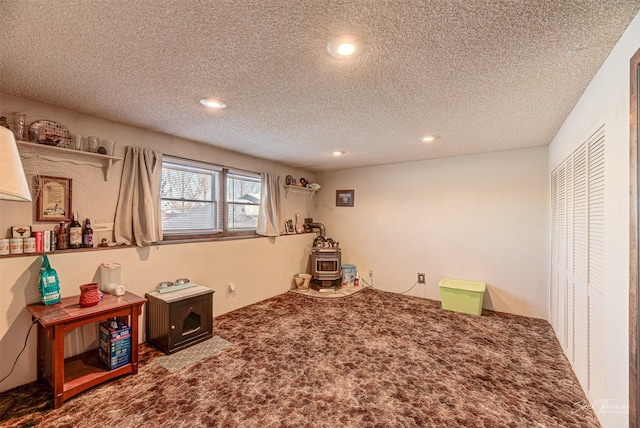 game room with a wood stove, carpet floors, and a textured ceiling