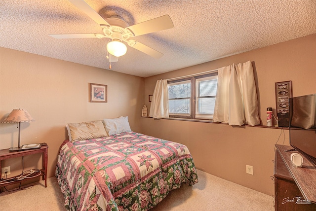 carpeted bedroom featuring a textured ceiling and ceiling fan