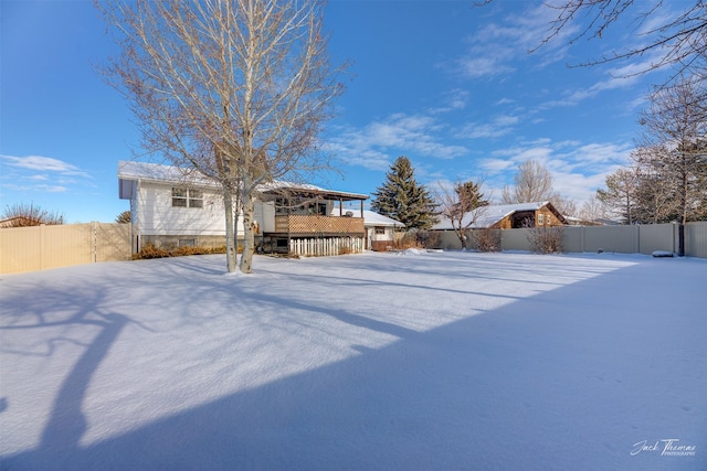 yard layered in snow with a deck