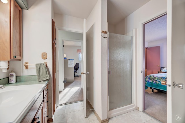 bathroom featuring tile patterned flooring, a textured ceiling, walk in shower, and vanity