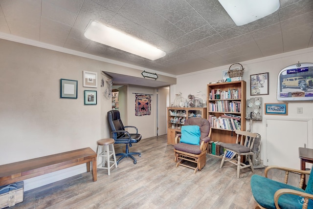 living area with ornamental molding and wood-type flooring