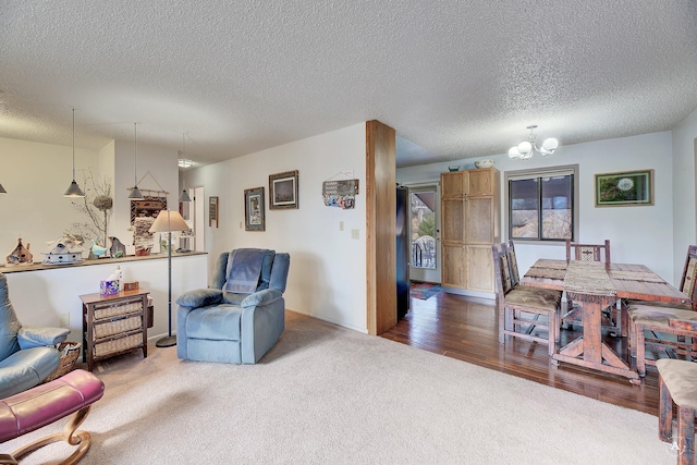 living room featuring a textured ceiling, a chandelier, and carpet