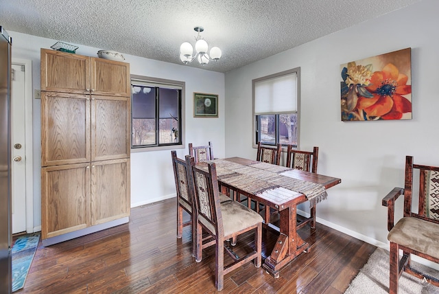 dining room featuring dark wood-type flooring, a textured ceiling, and an inviting chandelier