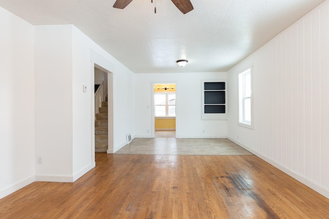 empty room with light wood-type flooring and ceiling fan