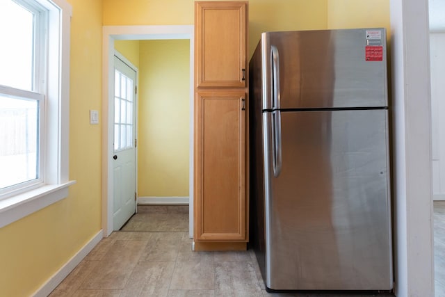 kitchen with plenty of natural light, stainless steel fridge, and light brown cabinets