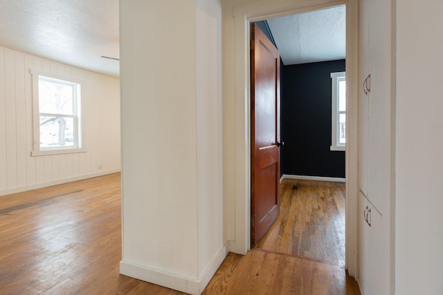 corridor featuring wood-type flooring and a textured ceiling