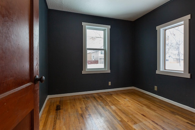 spare room with hardwood / wood-style floors and a healthy amount of sunlight