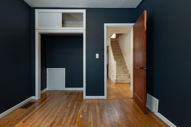 unfurnished bedroom with hardwood / wood-style flooring and a closet