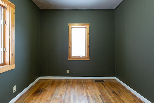 empty room featuring a textured ceiling and hardwood / wood-style flooring