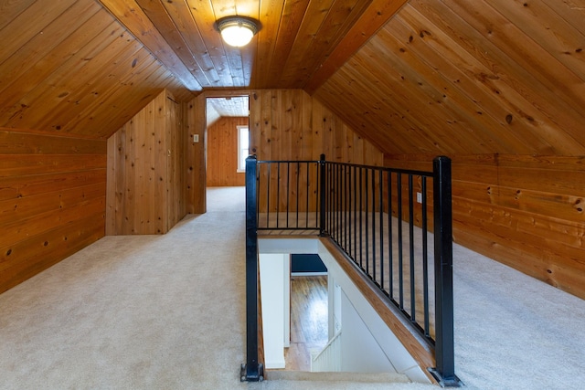 additional living space featuring wood walls, light colored carpet, wooden ceiling, and vaulted ceiling