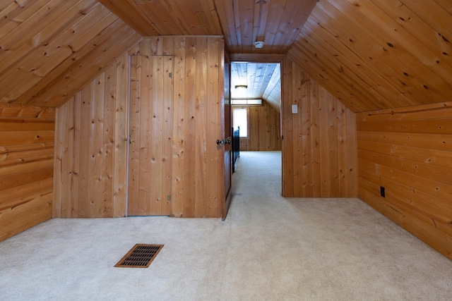 additional living space with wooden walls, lofted ceiling, and wood ceiling