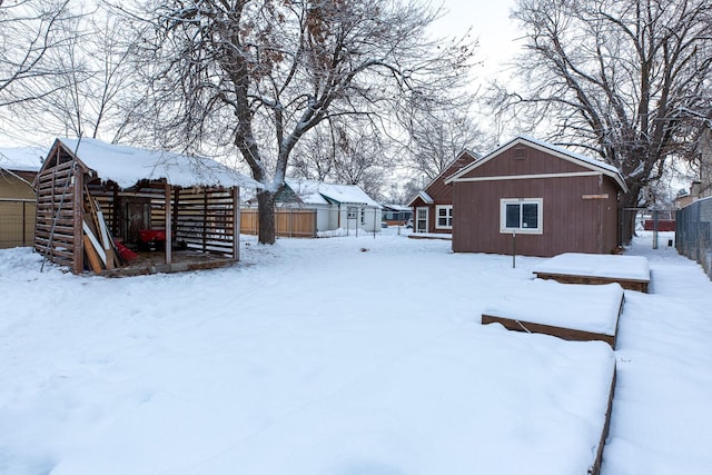 yard layered in snow featuring an outdoor structure