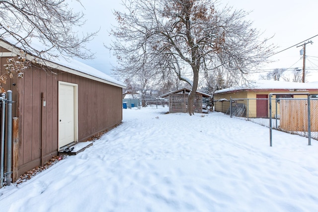 yard layered in snow featuring an outdoor structure