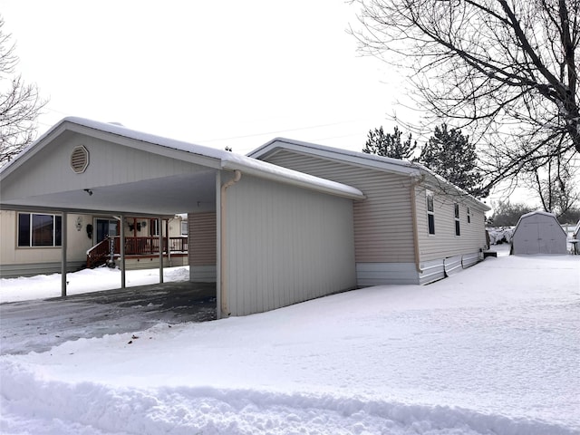 snow covered property with a carport