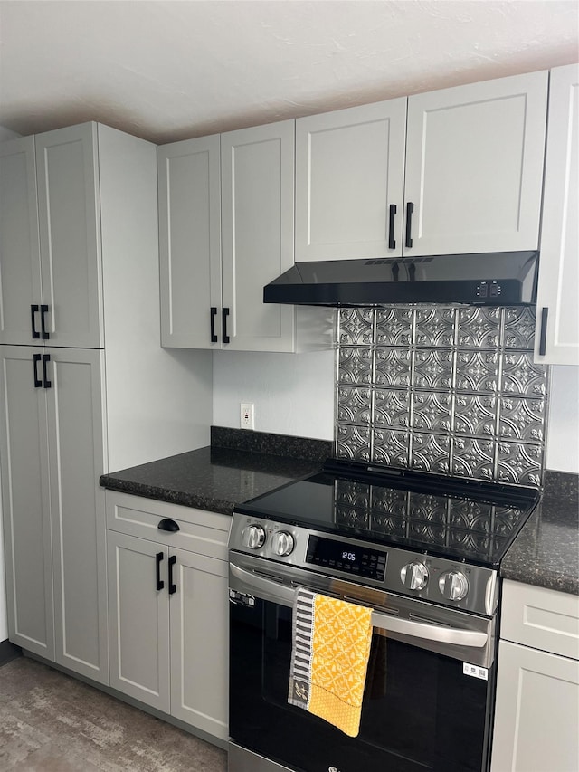 kitchen with white cabinetry, dark stone countertops, and electric stove