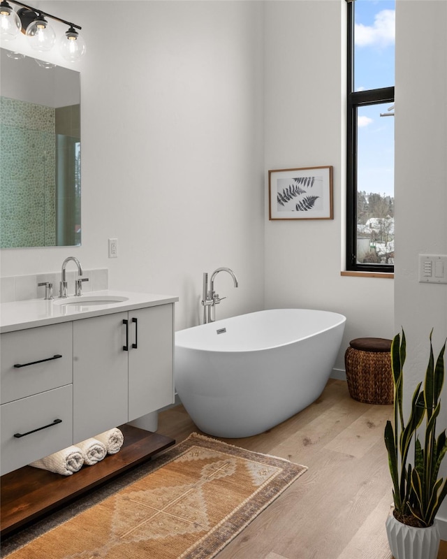 124 W 2nd St Unit B, Whitefish, MT 59937 - full bathroom with wood finished floors, vanity, a freestanding tub, and a shower with shower door