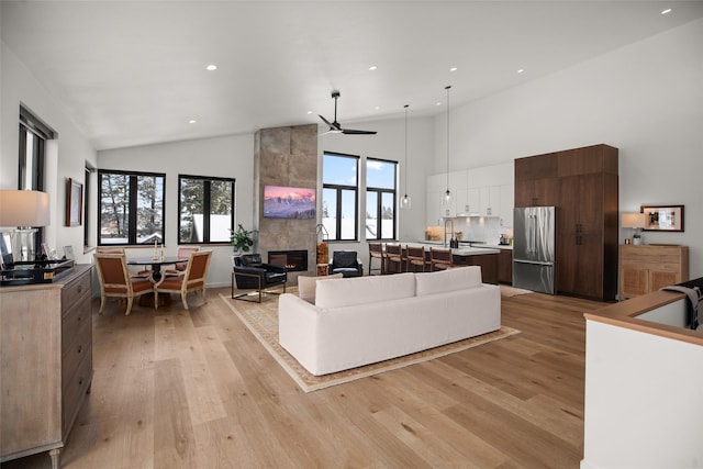 124 W 2nd St Unit B, Whitefish, MT 59937 - living area with high vaulted ceiling, light wood finished floors, a fireplace, a ceiling fan, and recessed lighting