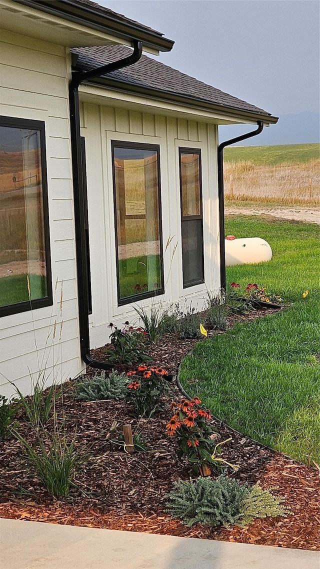 property entrance featuring a shingled roof and board and batten siding