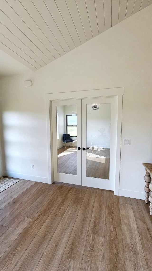 doorway with french doors, lofted ceiling, wood ceiling, wood finished floors, and baseboards