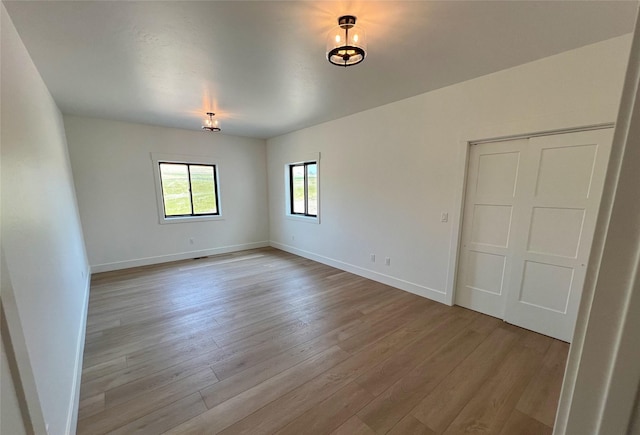 empty room with baseboards and light wood-style floors