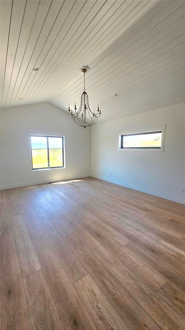 spare room featuring lofted ceiling, wood ceiling, a chandelier, baseboards, and hardwood / wood-style flooring