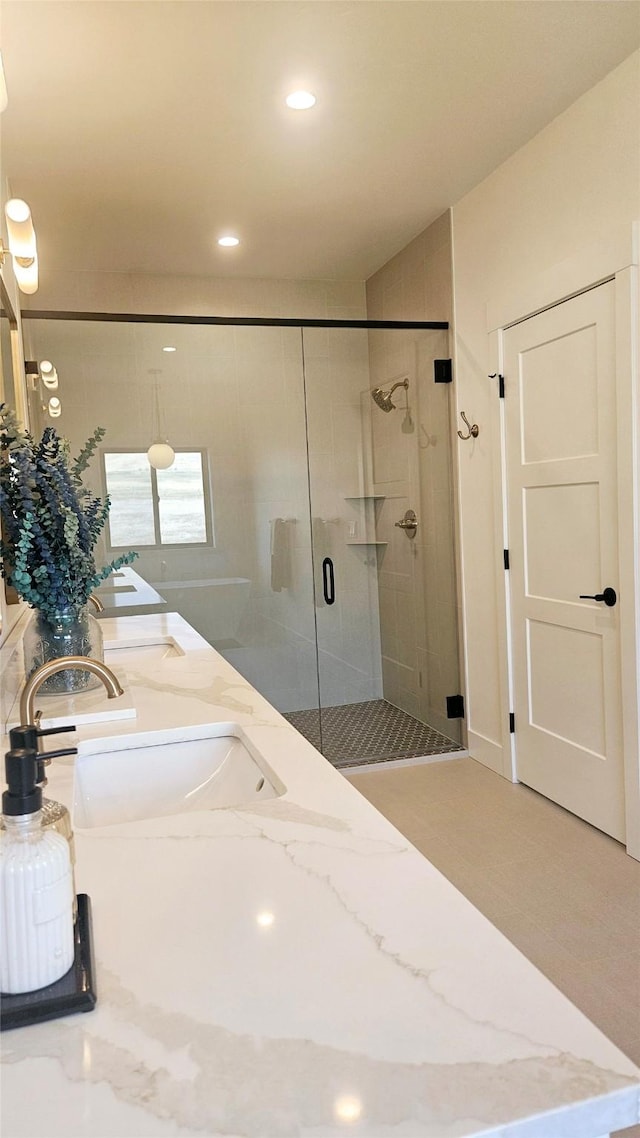 bathroom with recessed lighting, a sink, a shower stall, and double vanity