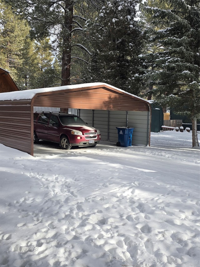 snow covered parking with a carport