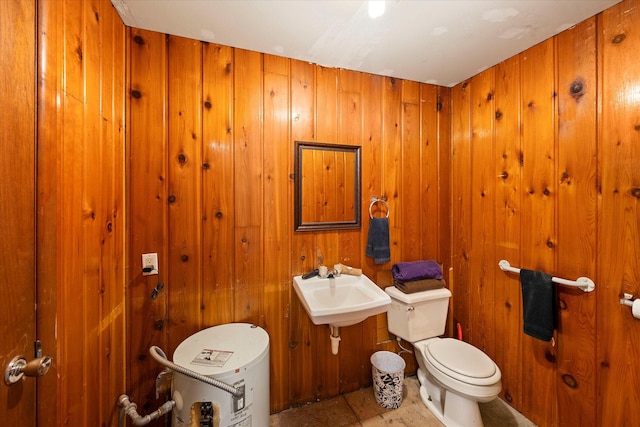 bathroom featuring sink, toilet, and wood walls