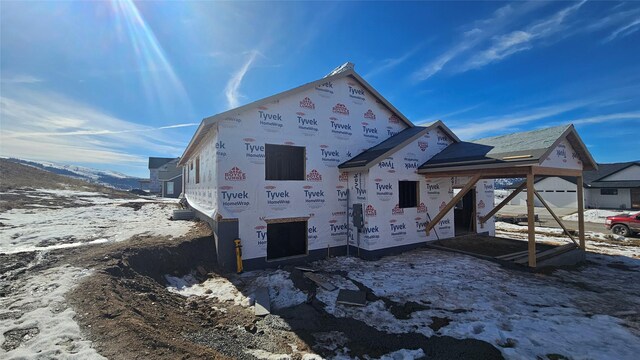 view of snow covered back of property