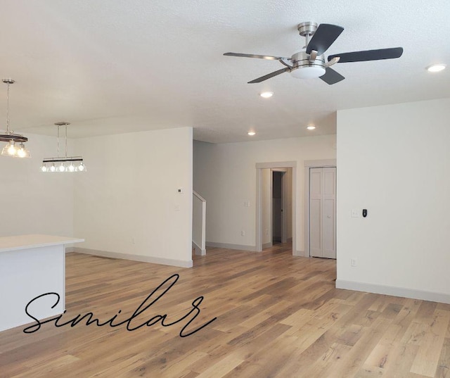 unfurnished room featuring light hardwood / wood-style floors, ceiling fan, and a textured ceiling