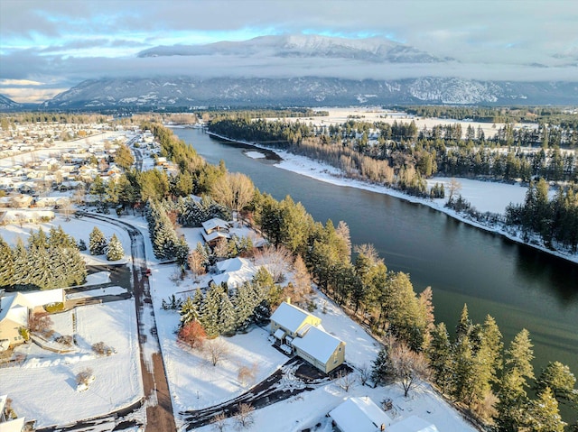 snowy aerial view featuring a water and mountain view