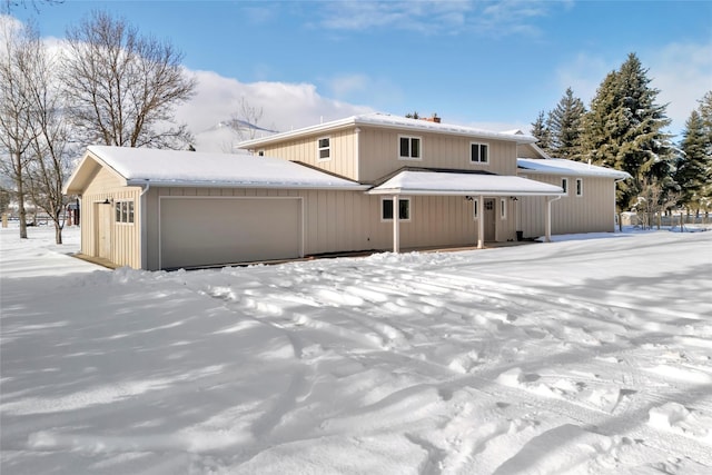 snow covered property featuring a garage