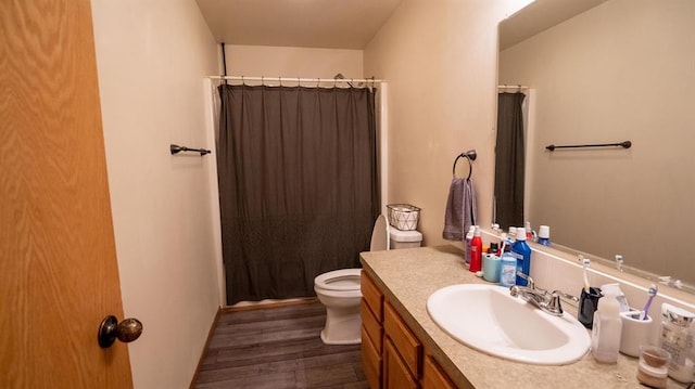 bathroom featuring walk in shower, hardwood / wood-style flooring, vanity, and toilet