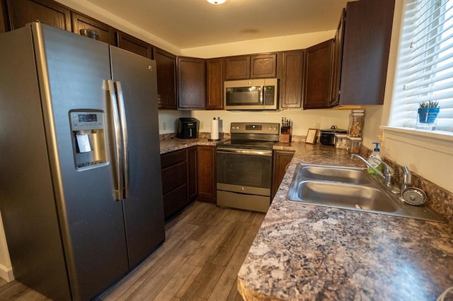 kitchen with dark hardwood / wood-style floors, sink, dark brown cabinets, and stainless steel appliances