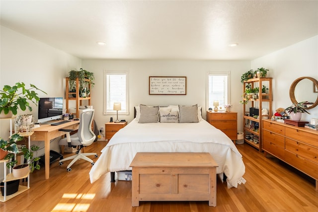 bedroom with light hardwood / wood-style floors and multiple windows