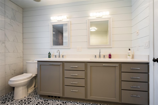 bathroom featuring vanity, wood walls, and toilet