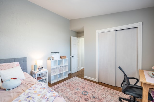 bedroom featuring a closet, dark wood-type flooring, and lofted ceiling