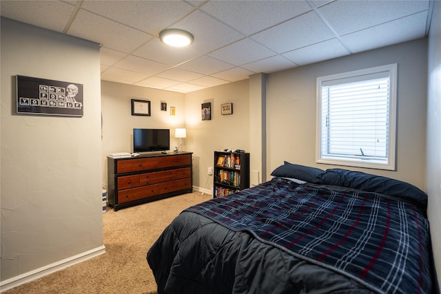 carpeted bedroom with a paneled ceiling