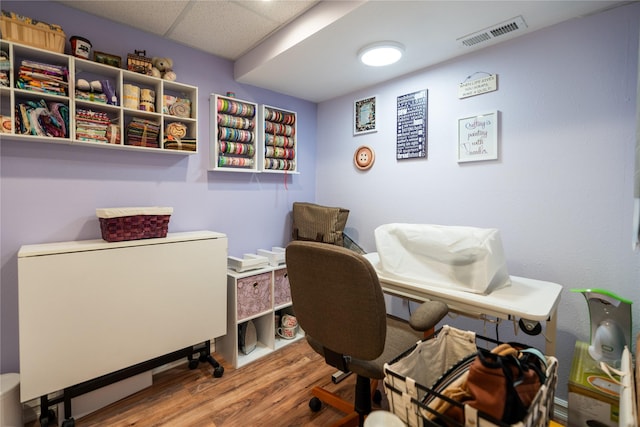 office space featuring a paneled ceiling and hardwood / wood-style flooring