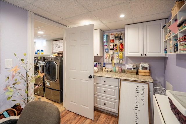 laundry area with washing machine and dryer and light hardwood / wood-style floors