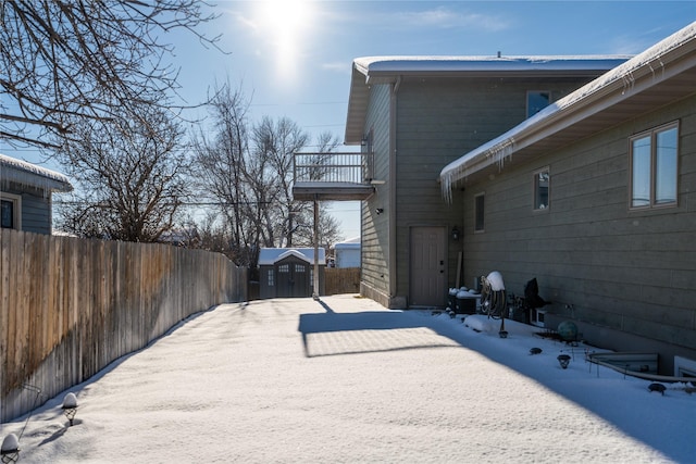 snowy yard featuring a storage shed