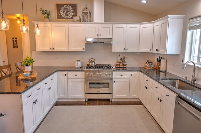 kitchen featuring stainless steel appliances, hanging light fixtures, white cabinetry, a sink, and under cabinet range hood