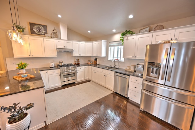 kitchen featuring decorative light fixtures, stainless steel appliances, white cabinetry, a sink, and under cabinet range hood