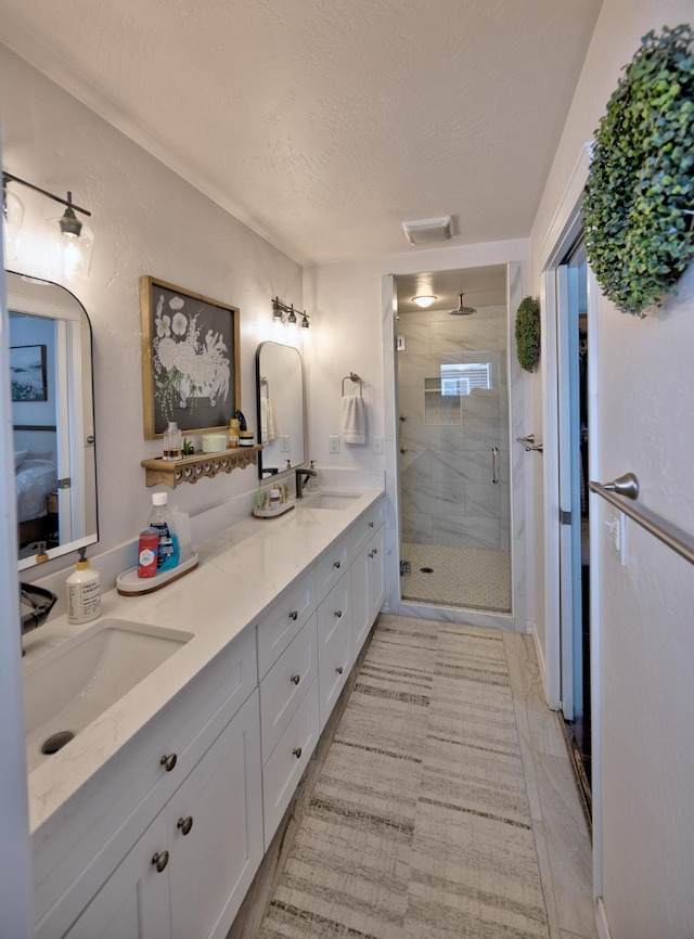 full bathroom with a stall shower, visible vents, a sink, and double vanity