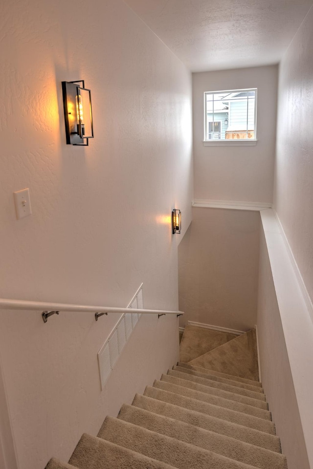 staircase with a textured ceiling